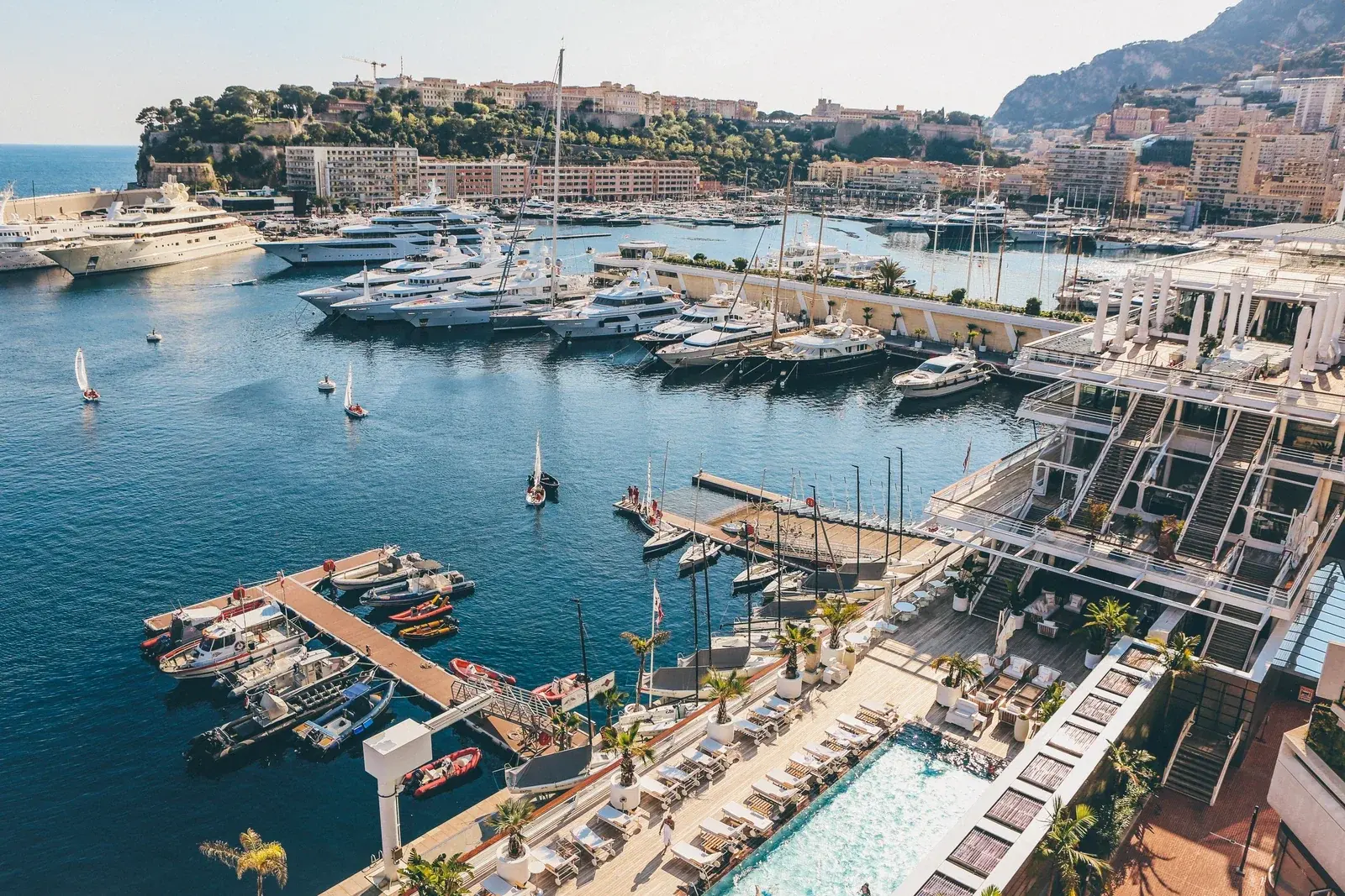 Superyachts and sailing boats moored in Port Hercule, Monaco, below the Rock on a clear morning
