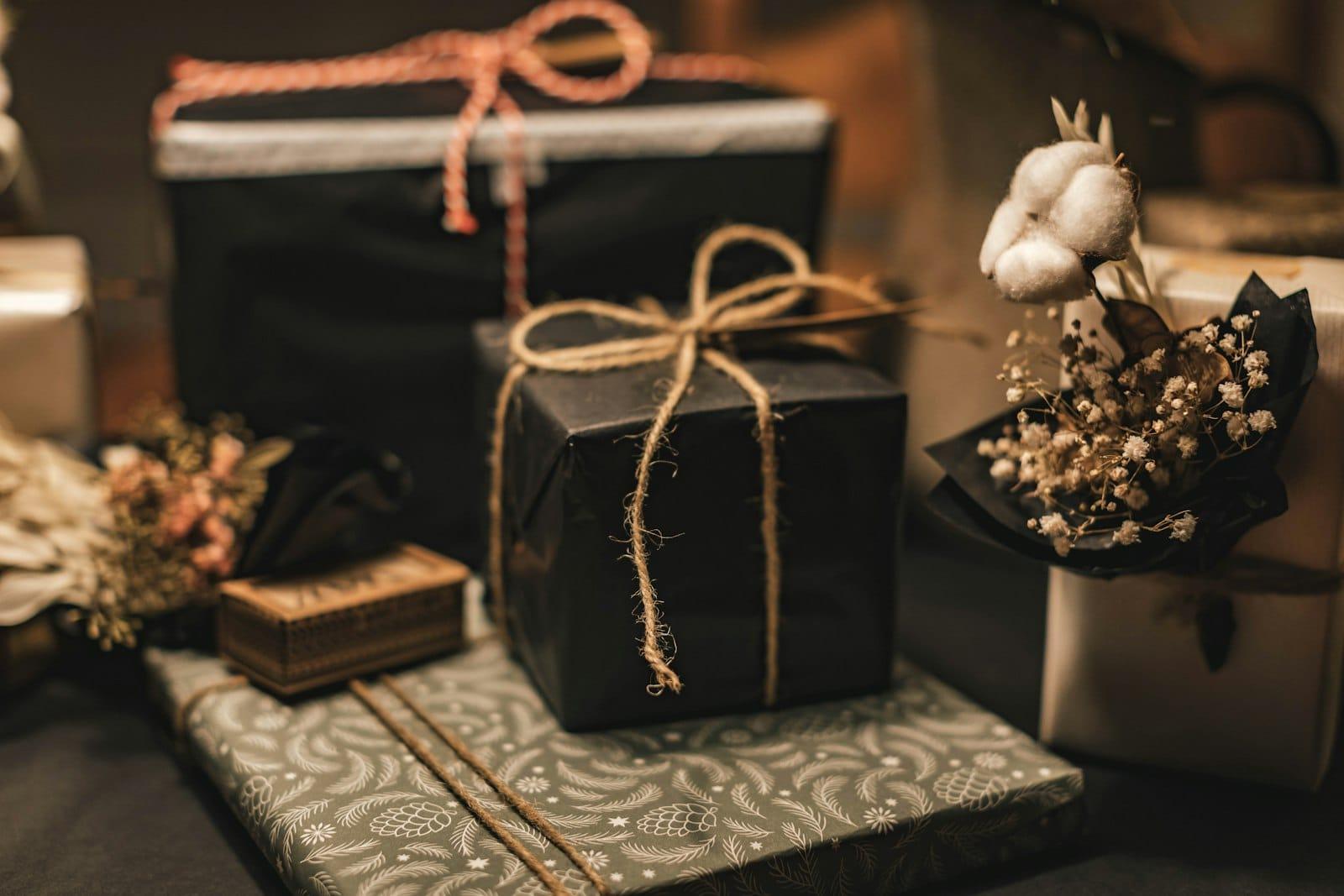 Wrapped parcels in black and patterned paper with twine, dried cotton and gypsophila